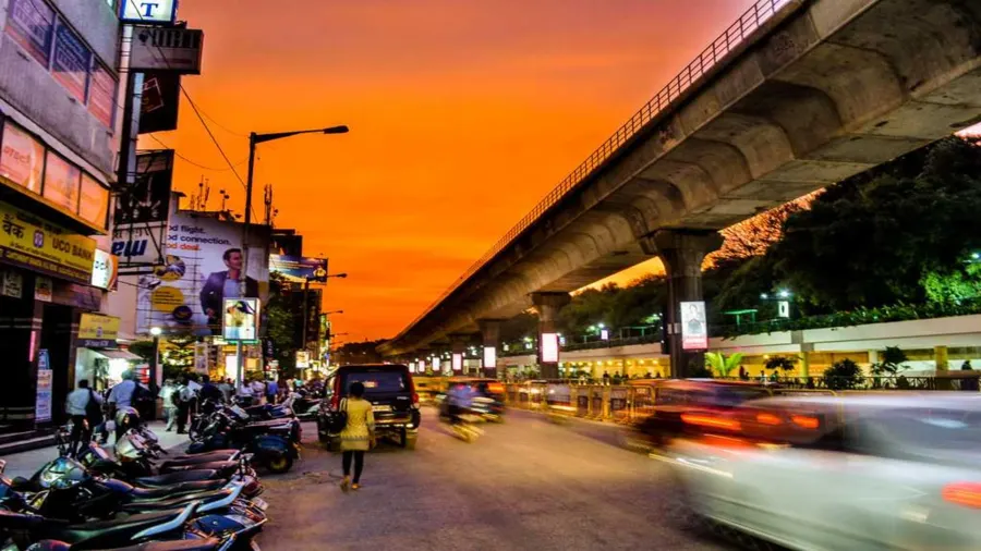 MG Road, Bangalore, at dusk with traffic and the elevated metro line